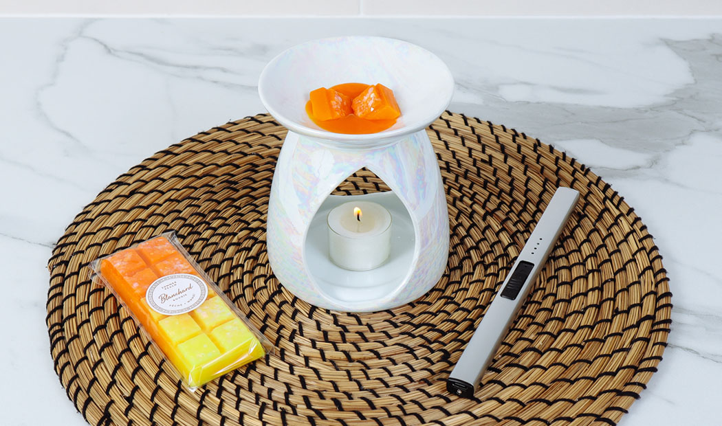 Brûleur à fondant en fonctionnement avec un fondant parfumé en train de fondre.